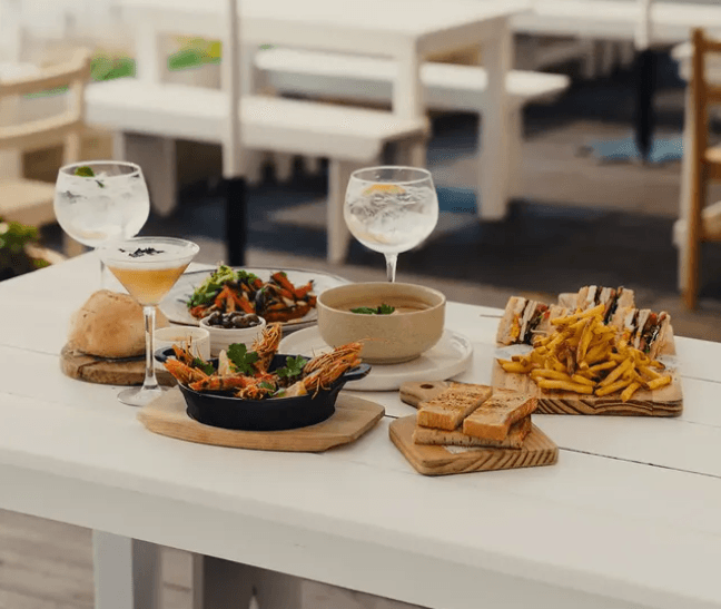 Food and cocktails on a table at Salty Beach Bar