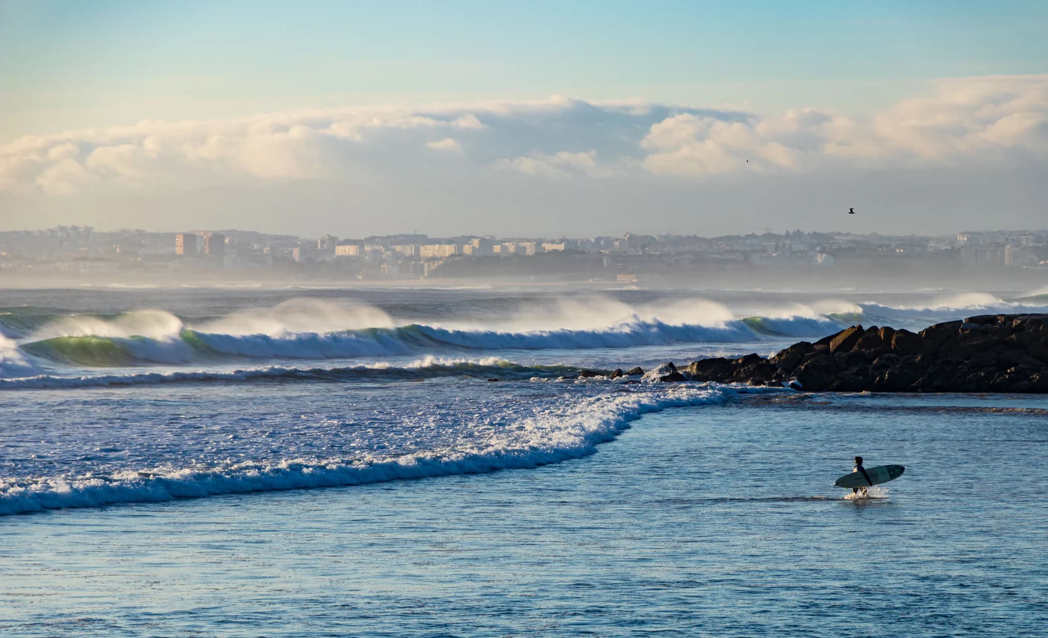 Surfer entering the water at Praia do CDS in Costa da Caparica